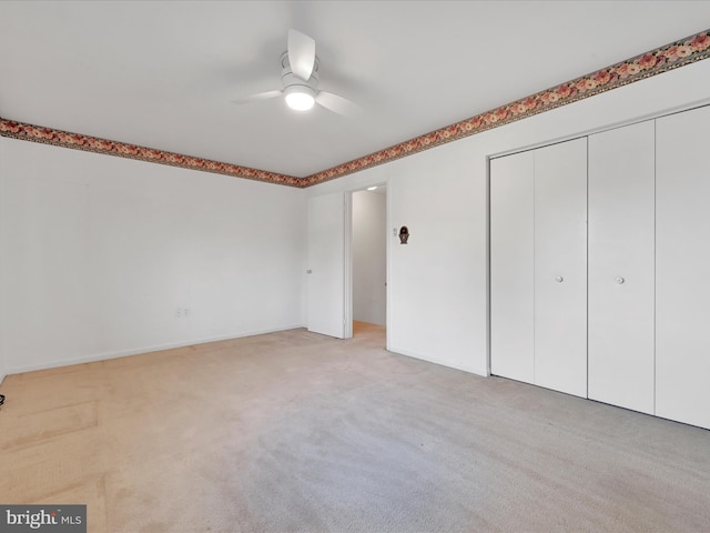 unfurnished bedroom with light carpet, a closet, and ceiling fan