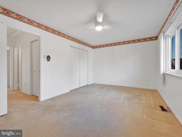 spare room featuring ceiling fan and light carpet