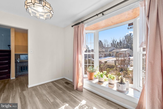 doorway featuring a fireplace and light hardwood / wood-style flooring