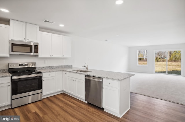 kitchen with white cabinets, appliances with stainless steel finishes, dark wood-type flooring, and sink