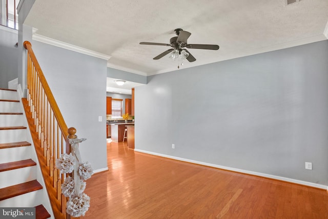 spare room featuring hardwood / wood-style floors, ceiling fan, a healthy amount of sunlight, and crown molding