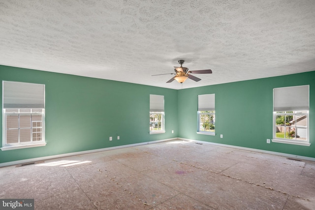 spare room with a wealth of natural light, ceiling fan, and a textured ceiling