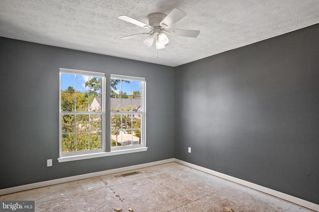 unfurnished room with ceiling fan and a textured ceiling