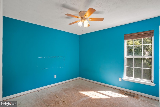 empty room with a textured ceiling and ceiling fan