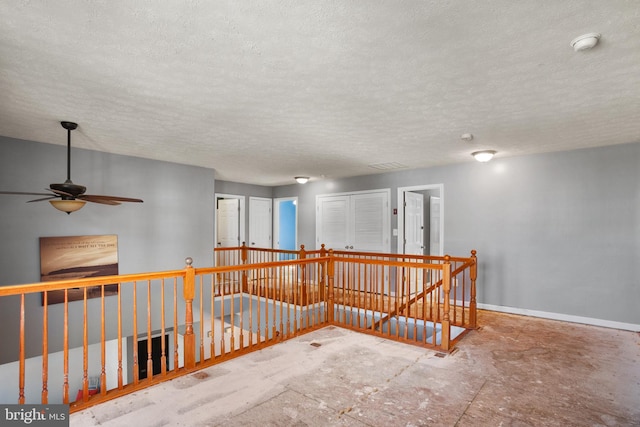 hall featuring a textured ceiling