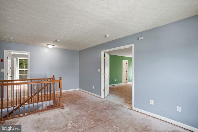 unfurnished room featuring a textured ceiling