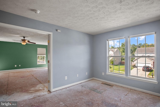 empty room with ceiling fan and a textured ceiling