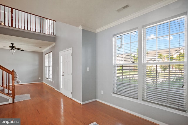 entrance foyer featuring hardwood / wood-style flooring, ceiling fan, and crown molding