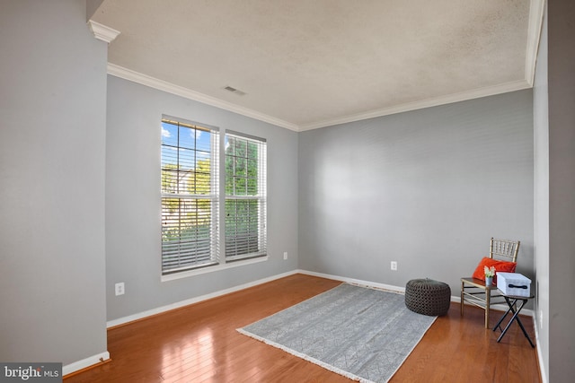 living area featuring hardwood / wood-style flooring and ornamental molding