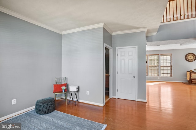 living area featuring wood-type flooring and crown molding