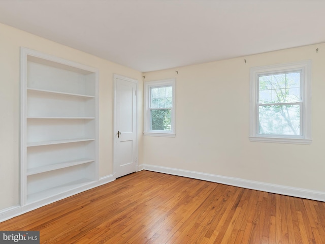 empty room featuring built in features and wood-type flooring