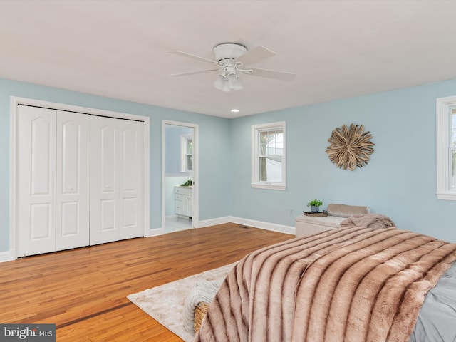 bedroom with hardwood / wood-style floors, ceiling fan, a closet, and ensuite bath