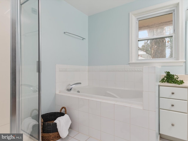 bathroom with tile patterned floors and tiled tub