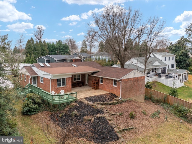 back of house featuring a deck and a patio