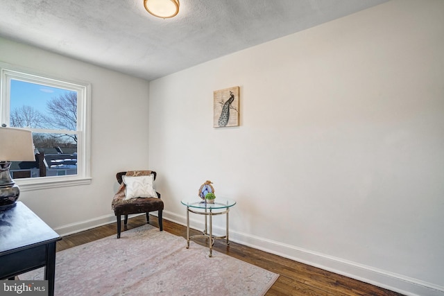 living area featuring dark wood-type flooring and a textured ceiling