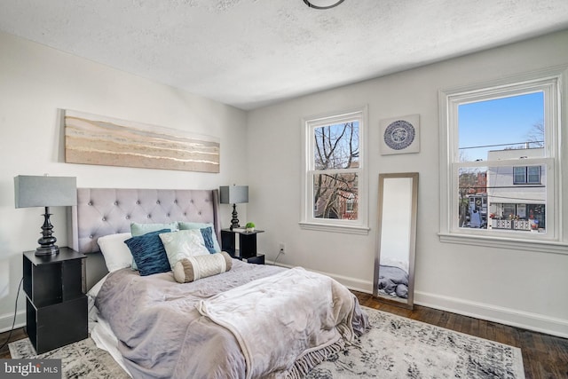 bedroom featuring dark wood-type flooring and a textured ceiling