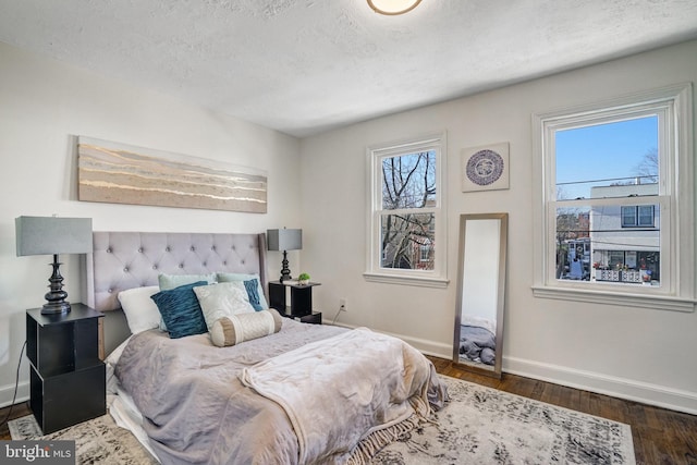 bedroom with a textured ceiling and dark wood-type flooring