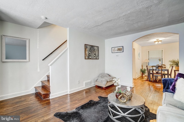 living room featuring a textured ceiling and dark hardwood / wood-style flooring