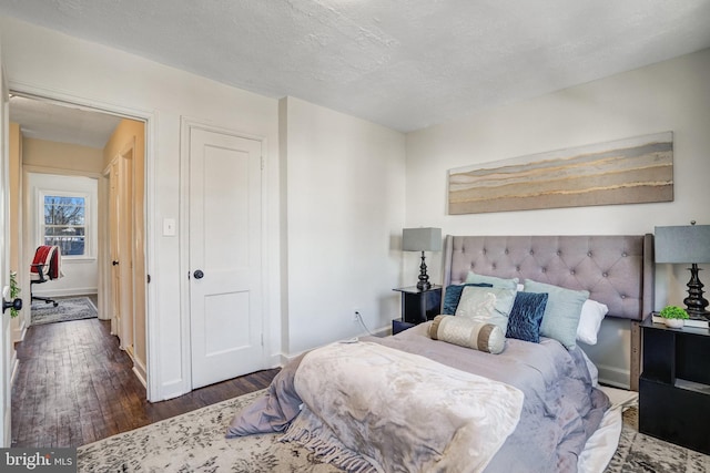 bedroom featuring a textured ceiling and dark hardwood / wood-style floors