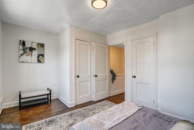 bedroom with dark wood-type flooring and a textured ceiling