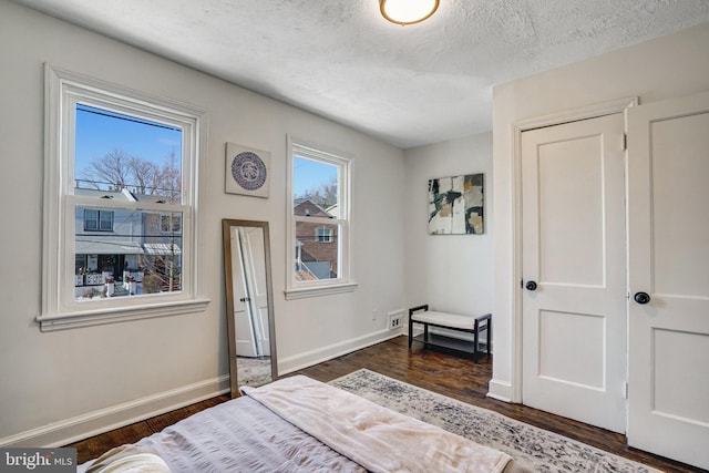 bedroom with dark wood-type flooring and a textured ceiling