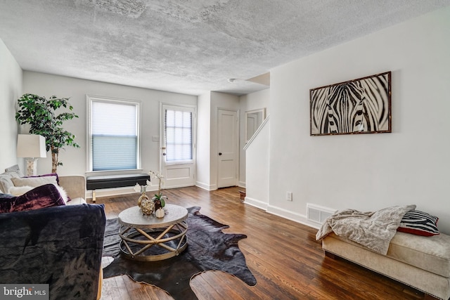 living room with dark wood-type flooring and a textured ceiling