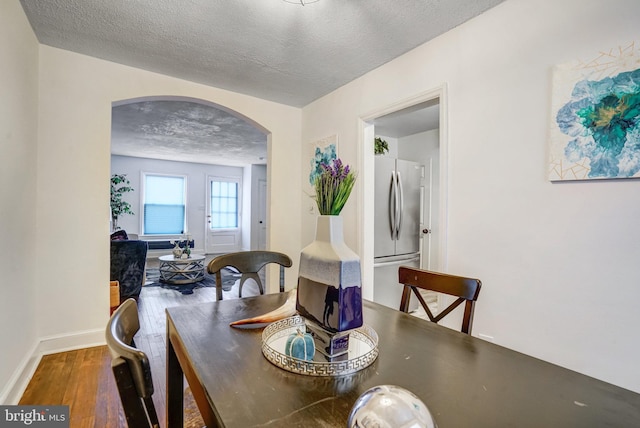 dining area featuring a textured ceiling and wood-type flooring