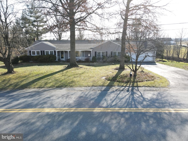 ranch-style home featuring covered porch and a front yard