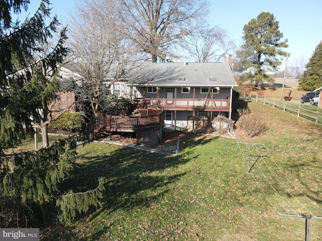 rear view of property featuring a deck and a yard