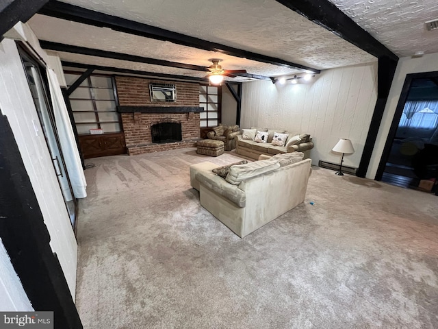 living room featuring ceiling fan, a fireplace, a textured ceiling, beamed ceiling, and carpet floors