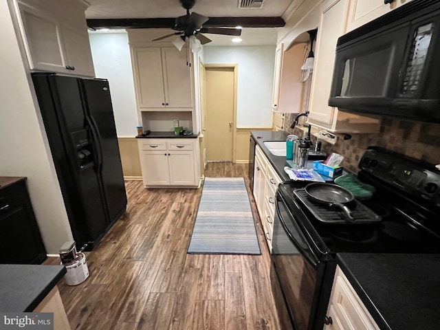 kitchen with white cabinetry, sink, black appliances, and hardwood / wood-style flooring