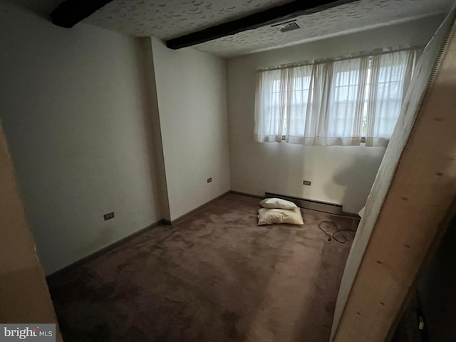 carpeted empty room featuring baseboard heating, beamed ceiling, and a textured ceiling