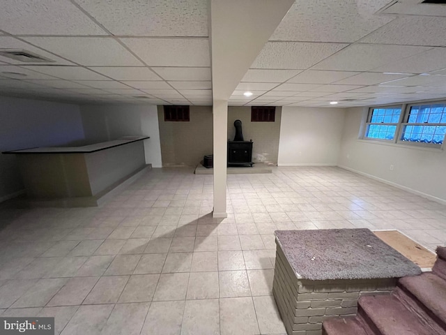 basement featuring a drop ceiling and light tile patterned floors