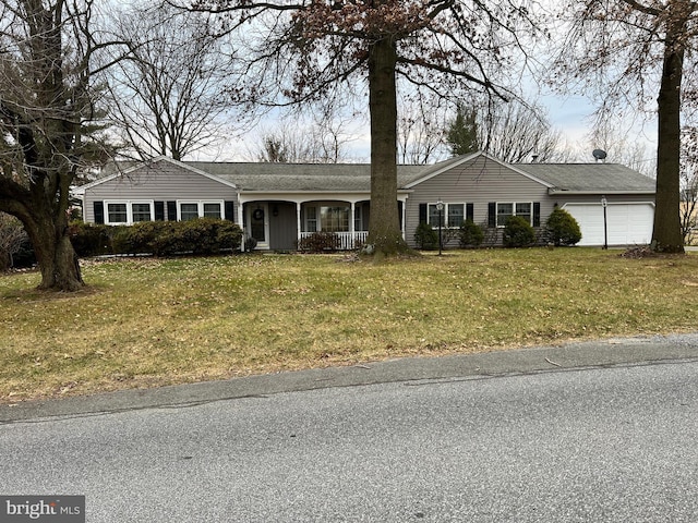 ranch-style house featuring a porch, a garage, and a front lawn