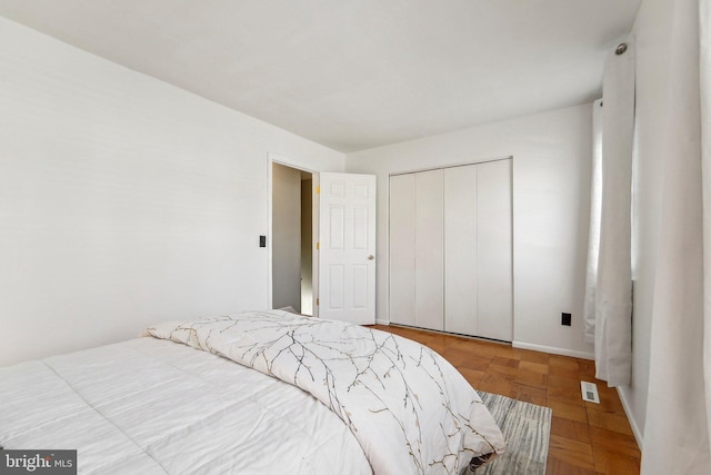 bedroom featuring a closet and parquet flooring