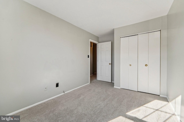 unfurnished bedroom featuring a closet and light carpet