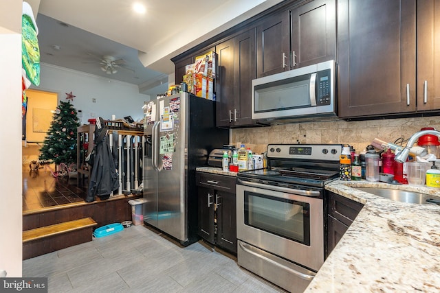 kitchen featuring ceiling fan, light stone countertops, dark brown cabinetry, and stainless steel appliances