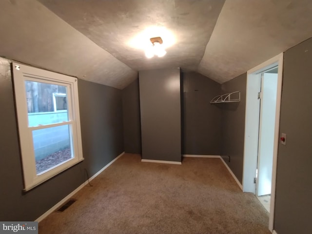 additional living space with lofted ceiling and light carpet