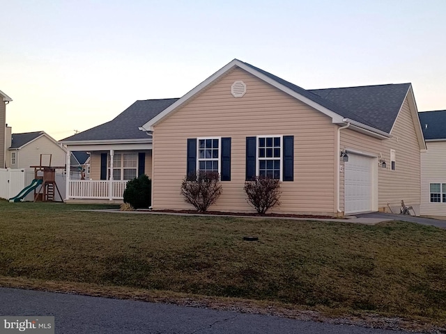 ranch-style house featuring a lawn, a garage, and covered porch