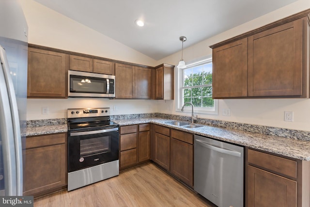 kitchen with lofted ceiling, sink, light hardwood / wood-style flooring, light stone countertops, and stainless steel appliances