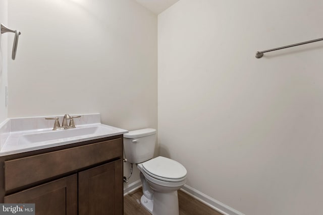 bathroom featuring wood-type flooring, vanity, and toilet