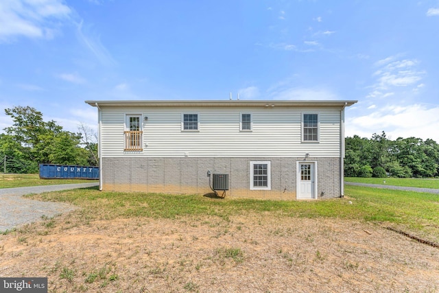 back of property featuring a yard and cooling unit