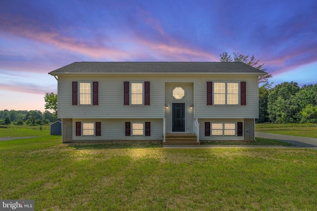 split foyer home featuring a yard