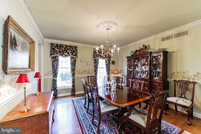 dining area featuring a notable chandelier, ornamental molding, and dark hardwood / wood-style floors