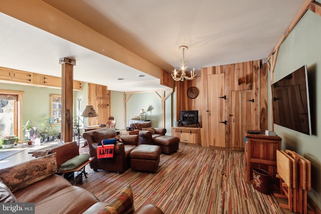 living room featuring radiator heating unit, decorative columns, carpet, a chandelier, and wood walls