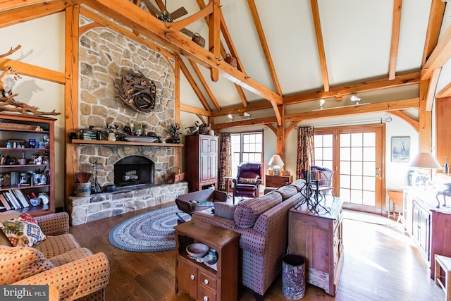 living room with beam ceiling, hardwood / wood-style flooring, a fireplace, and high vaulted ceiling