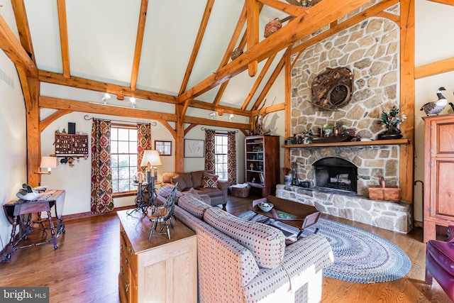 living room with dark hardwood / wood-style floors, a fireplace, high vaulted ceiling, and beam ceiling