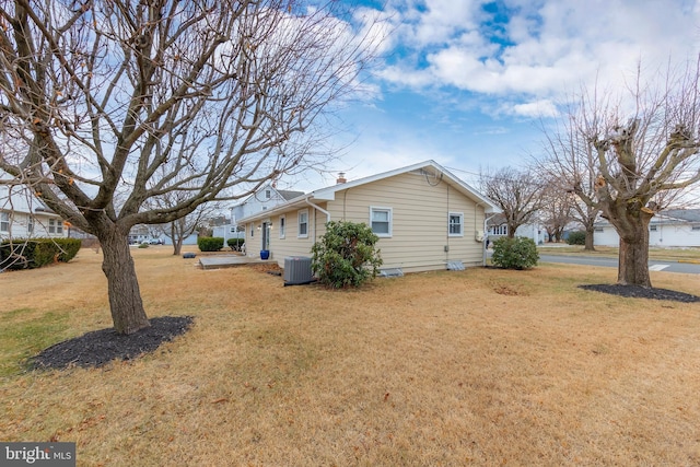 view of property exterior featuring cooling unit and a lawn