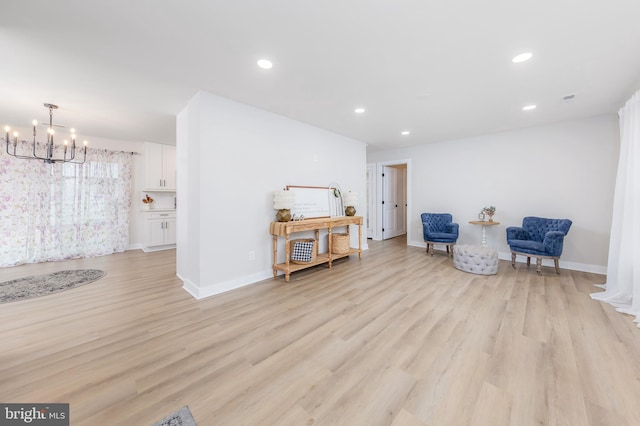 living area with light hardwood / wood-style flooring and a notable chandelier