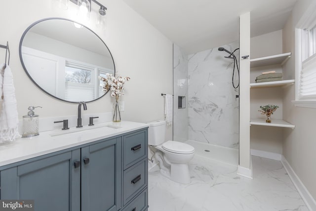 bathroom with toilet, vanity, and a tile shower